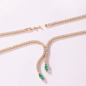Detailed view of a gold-toned zircon tennis necklace with green marquise stones