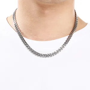 Detail view of a 8mm stainless steel Cuban link necklace worn on a model's neck.