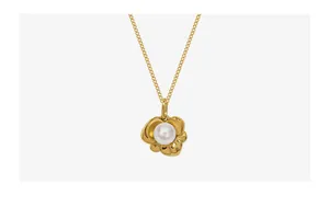 Detail der 18k vergoldeten Halskette mit Lotus-Anhänger und weißer runder Perle mittig