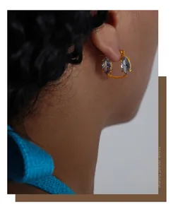 Close-up of gold hoop earrings with marquise-cut lavender crystals worn by a model