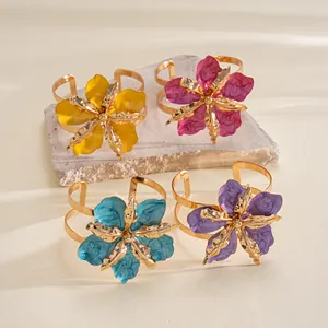 Detailed view of artistic metallic flower cuffs with colorful enamel pleated petals.