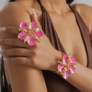 Detail of pink enamel flower bangle and ring set with wrinkled gold-toned metal accents