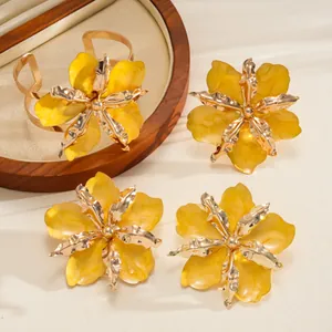 Close-up of metallic enamel yellow flower jewelry set with cuff bracelet and earrings