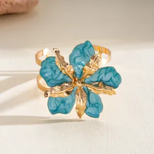 Macro detail of a high-end metallic cuff bracelet featuring a turquoise marbled flower