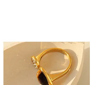 Detailansicht des vergoldeten V-Rings mit braunem Stein und kleinen Diamantakzenten