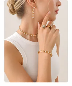 Detailed close-up of gold chain jewelry set with square zircon insets on a model