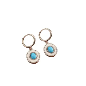 Roségouden roestvrijstalen creolen met turquoise ovale hanger en kristallen halo