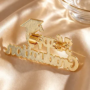 Detailed close-up of a gold-plated Happy Graduation brooch with mortarboard icon