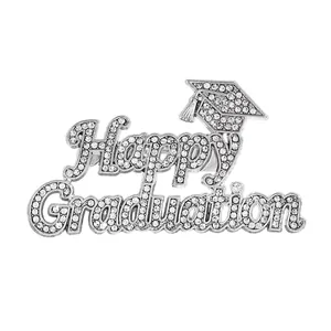 Detailed view of a silver graduation brooch with Happy Graduation text and rhinestones