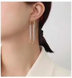 Detail of 18K gold plated U-shaped drop earrings with zircon stones on female model