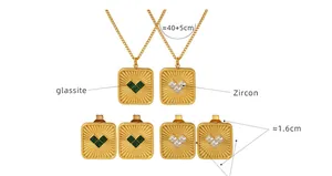 Detail van gouden rechthoekige hangers met groen glas en witte zirkonia hartstenen