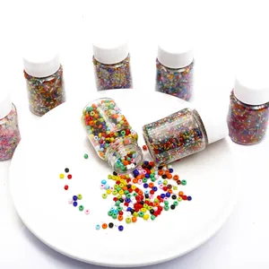 Colorful assorted glass seed beads in small clear bottles for DIY jewelry making