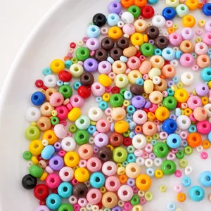Macro view of colorful round glass seed beads in a white ceramic dish for DIY jewelry