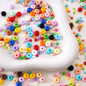 Macro shot of colorful mixed glass beads for DIY jewelry making on white wavy tray