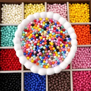 Vue détaillée de perles acryliques colorées de 6mm dans un plateau en bois pour DIY