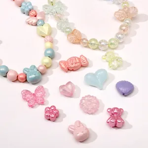 Makroaufnahme von Makronenfarbenen Acrylperlen in Herz-, Hasen- und Bonbonform für DIY-Schmuck