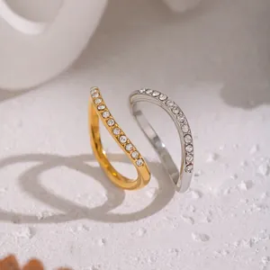 Dettaglio ravvicinato di anelli curvi in acciaio inossidabile con strass luccicanti.