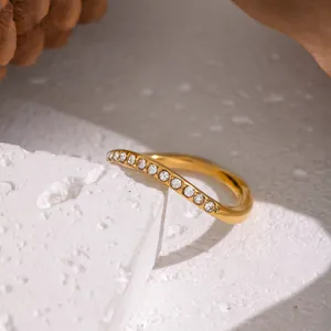 Dettaglio macro di un anello ondulato dorato in acciaio inossidabile con strass chic
