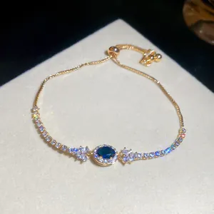 Luxuriöses elegantes goldfarbenes Armband mit blauem Mittelstein und glänzenden Zirkonen