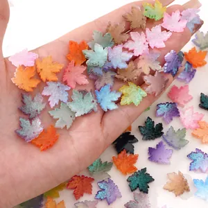 Detail of colorful resin maple leaf charms with gold glitter for DIY jewelry making