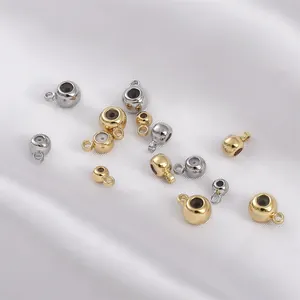 Détail de perles plaquées or 14K et argent avec anneaux sur tissu en soie blanche