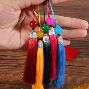 Dettaglio di cinque nappe di seta colorate con cappucci argentati per accessori fai-da-te