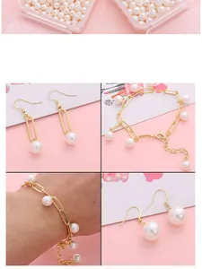 Dettaglio del set di gioielli dorati con eleganti perle di vetro bianche