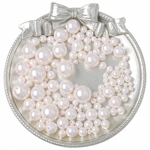 Eleganti perle finte bianche per gioielli fai da te su un vassoio d'argento