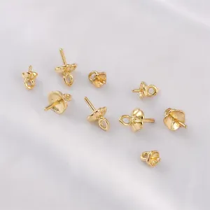 Makroaufnahme von 14K goldgefüllten Perlenkappen für DIY-Schmuck auf weißer Seide