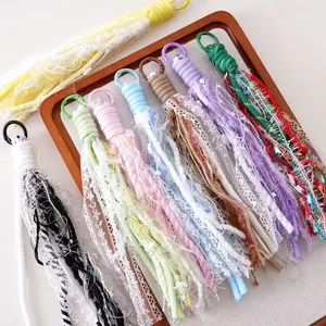 Boho lace tassel keychains with colorful alloy hooks in a wooden tray display