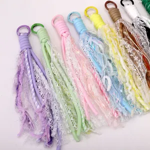Close-up of handmade colorful polyester lace tassels with metal key rings for DIY bags