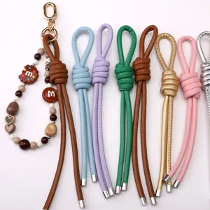 Close-up of colorful braided faux leather Peru knot pendants with beads and gold spring hooks