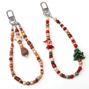 Handmade Christmas beads pendant with Santa and tree motifs on white background