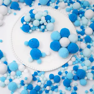 Dettaglio di pompon soffici blu e bianchi per progetti creativi e artigianato DIY