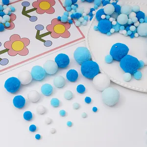 Pompon di peluche blu e bianchi di varie dimensioni su un piatto bianco decorativo