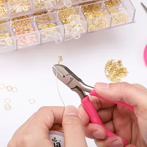 Macro view of pink jewelry side cutters cutting gold metal wire for DIY crafting