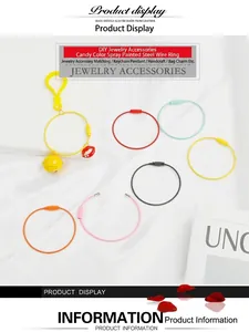 Detail of colorful candy-colored wire keychains with charms on white silk fabric