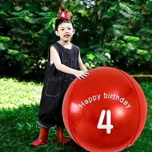 Detail of red 4th birthday party set with giant balloon and matching crown on grass