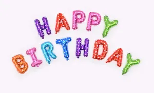 Close-up of colorful HAPPY BIRTHDAY foil balloons with white heart polka dot patterns