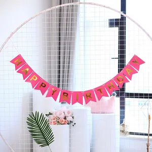 Detailed view of pink Happy Birthday fishtail banner with gold foil lettering on a white grid