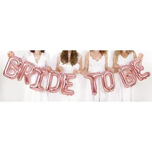 Détail de ballons Bride To Be en aluminium or rose portés par des modèles pour enterrement de vie