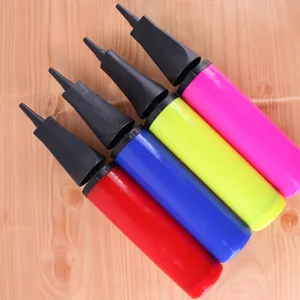 Portable manual balloon air pumps in four vibrant colors on a wooden background