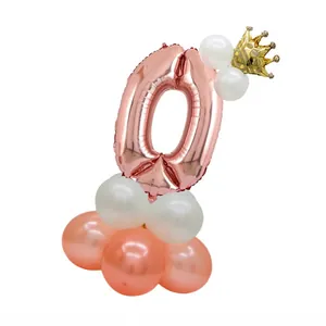 Rose gold number 0 balloon with crown on a white and pastel pink latex stand