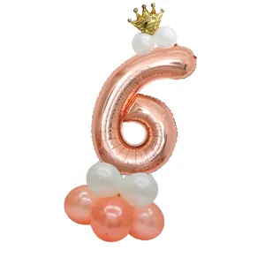 Detail of rose gold number 6 balloon with crown topper and latex base for parties