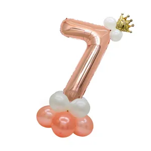 Detail of rose gold number 7 balloon with golden crown and pink latex base pillar