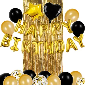 Dettaglio del set compleanno con palloncini dorati e tenda a frange metallizzate