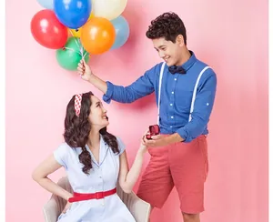 Scène de demande en mariage avec bague dans un coffret rouge et ballons de fête colorés
