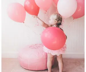 Pouf rose en cuir synthétique brodé avec des ballons roses dans un cadre festif doux