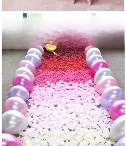 Décoration de sol romantique avec ballons nacrés et pétales de rose colorés