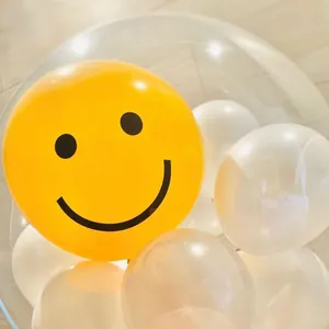 Yellow smiley face balloon inside a transparent bobo ball for birthday party decoration